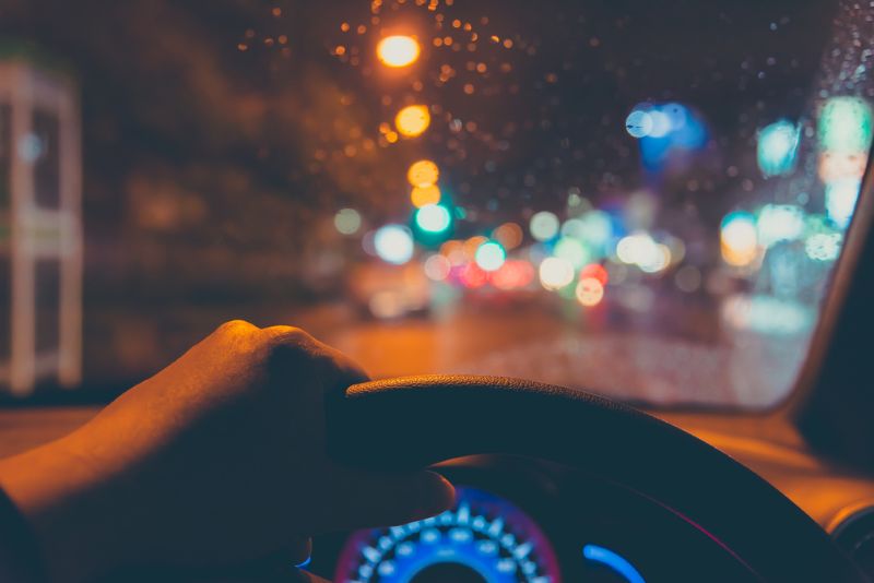 hand on steering wheel at night time