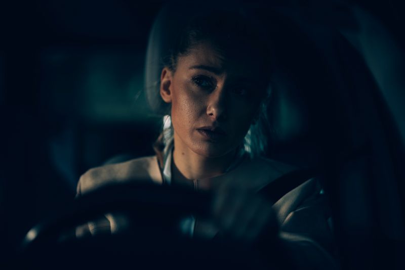 Anxious woman driving at night