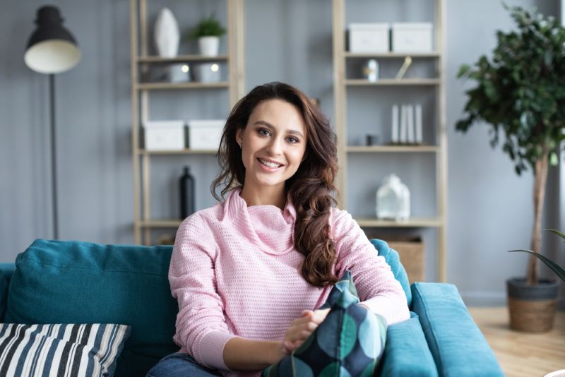 Woman smiling on her couch in her home